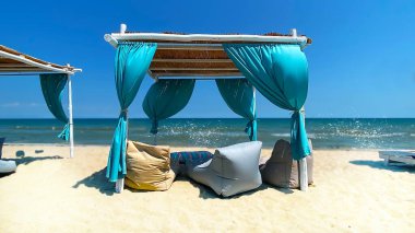  mavi çadır hasır şemsiyeler mavi gökyüzü tropikal tatil beldesi yabani bitki, Yunanistan 'da plaj tatil beldesinde beyaz kum