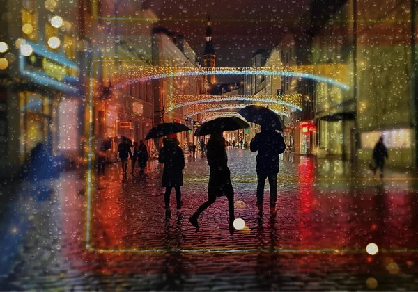 사람들은 거리에서 우산을 가지고 실루엣을 창문에는 내리는 내리고 있습니다 — 스톡 사진