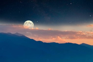Gün batımında sisli dağlar. Turuncu akşam. Yıldızlı mavi gece gökyüzü.