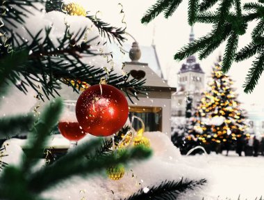   Noel ağacı yeşil dallı kırmızı top konfetisi ve sarı çelenk aydınlatması bir cam sarmaşık ve romantik fener mumu ile karlı cadde ortaçağ Tallinn 'inde eski kış havası 