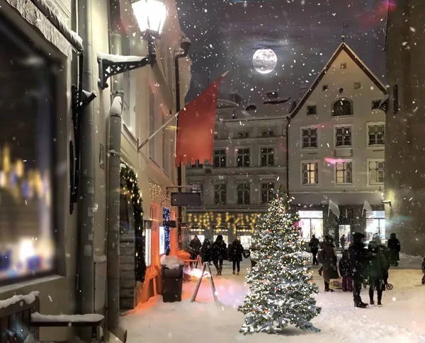 Ortaçağ şehir caddesinde akşam vakti aydınlatılmış Noel ağacı, vitrinlerde fener ışığı bulanık, gece gökyüzü dolunayı insanlar Tallinn 'deki eski kasaba meydanında karlı havada yürüyor. 