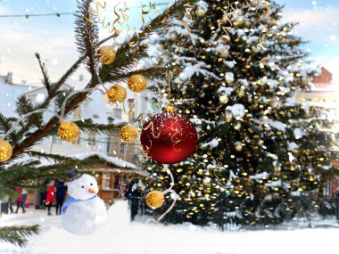  Ağaç dalına kırmızı top çelengi konfeti ve Noel ağacı yakınındaki karlı kış konfetisi ve Tallinn 'deki eski kasaba meydanındaki ortaçağ aydınlatması Avrupa' da tatil seyahatinde dinlenen insanlar. 