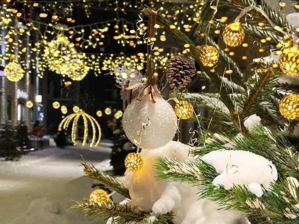 Tallinn 'deki bulanık ışık gecesinde beyaz balo ve kar sarısı konfeti süslemeli Noel ağacı Estonya' ya eski bir kış tatili seyahati