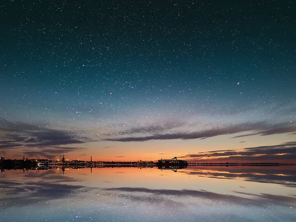  city light on Baltic sea Tallinn old town star on sky blue night  starry sky on pink yellow sunset at sea water vawe reflection blurred light full moon moonlight  skyline  nebula nature background 