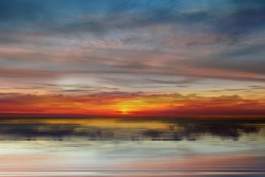 Gökkuşağı dramatik pembe gün batımı sarı mavi bulutlu dramatik mavi gökyüzü deniz suyu arka planına yansıyor.