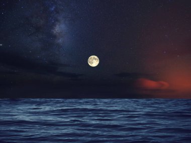Bulutlu gece dramatik gökyüzü nebula yıldızlı gökyüzü büyük ay ve koyu mavi deniz suyu dalgası Auror Borealis arka plan fotokopi uzay şablonu