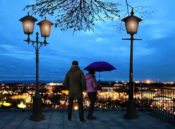 中世タリン旧市街のパノラマ 街灯のシルエット エストニアへの旅行で都市の夜の光を見て都市の散策に傘を持つロマンチックなカップル青い夜 — ストック写真