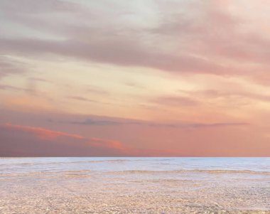 Denizde gökyüzünde tropikal pembe bulutlar, deniz dalgaları ve plajda beyaz kum yaz arka planında. 