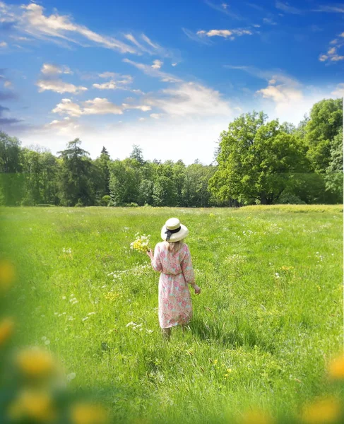 romantic woman with flowers relaxing on wild field ,blue sky with white clouds   ,herbs and grass summer nature landscape weather forecast sunny day