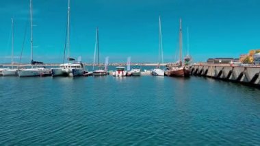 Baltık Denizi Limanı, limandaki yat teknesi güneşli bir günde deniz suyuna, marinaya ve yahtlere yansıyor. 