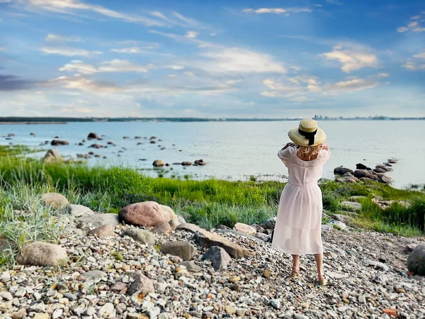 woman relax  on nature on beach wild field  and looks at the sea on the horizon summer nature landscape background