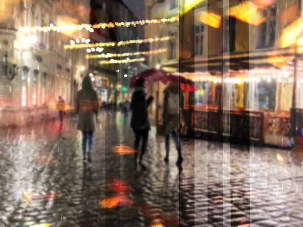 christmas rain rainy city night light street reflection people with umbrellas buildings blurred light red yellow bokeh vew from window urban Tallinn old town medieval holiday lifestyle
