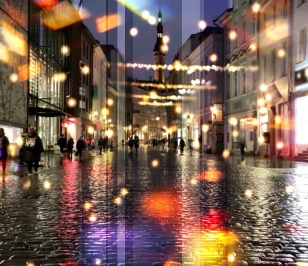 rainy  city night light  street reflection people walk in Tallinn old town  medieval  buildings vitrines  blurred light red yellow bokeh vew from cafe window urban festive illumination decoration,holiday  travel to Estonia