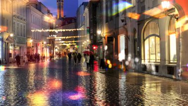  Yağmurlu şehir gece lambası sokak yansıması Tallinn 'de eski kasaba ortaçağ binalarında insanlar yürüyor vitrinler bulanık kırmızı bokeh vew Kafe penceresinden kentsel aydınlatma dekorasyonu, Estonya' ya tatil seyahati