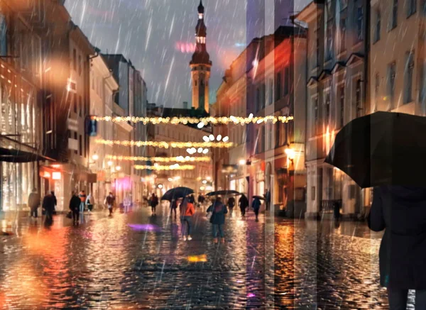 抽象的な背景雨のお祝い都市の夜のライト人々は中世タリン旧市街のライフスタイルビューで傘で歩く窓旅行からエストニアへ — ストック写真