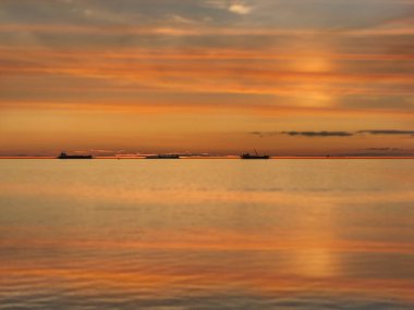  Ufuktaki deniz suyu yansıtma gemisinde turuncu altın gün batımı bulutlu doğa deniz manzarası