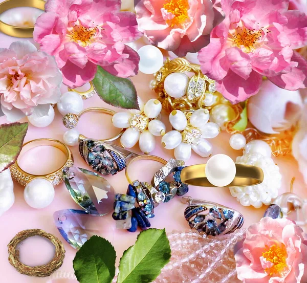 woman jewelry gold rings white pearl blue citrin  gem stones  pink roses and green  leaves on pastel pink light background banner