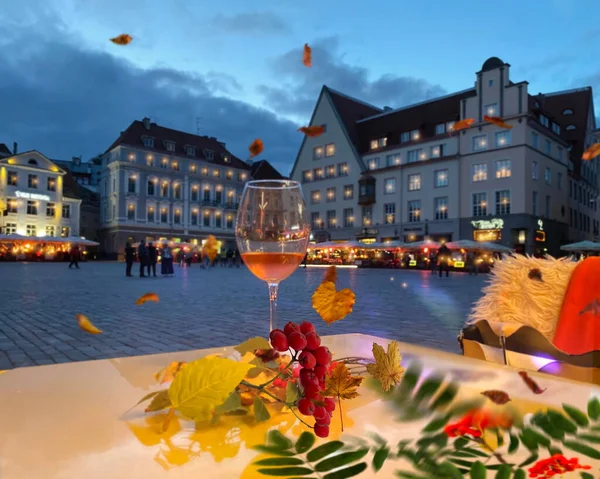 rainy Evening blurred light Autumn in Tallinn old town hall square street cafe rain drops on window glass of water ash berry and yellow leaves fall weather forecast season in Estonia