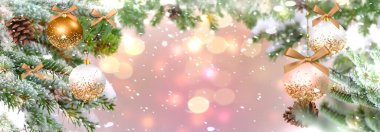 Christmas banner gold ball and green pine tree branch with cone winter blurred pink background copy space template banner