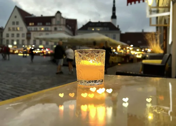 candle light on street cafe table in evening city people walking and relax in Tallinn old town hall square travel to Estonia.