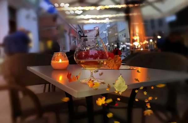 street cafe  candle light and glass wine on table and yellow leaves fall evning city lifestile