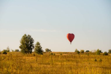Sıcak hava balonu havada süzülüyor büyük kırmızı sıcak hava balonu büyük bir kalp şeklinde aşk ve dünya barışı için