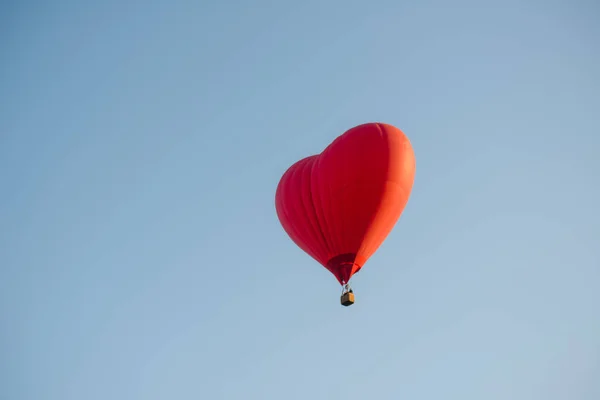 Sıcak hava balonu havada süzülüyor büyük kırmızı sıcak hava balonu büyük bir kalp şeklinde aşk ve dünya barışı için