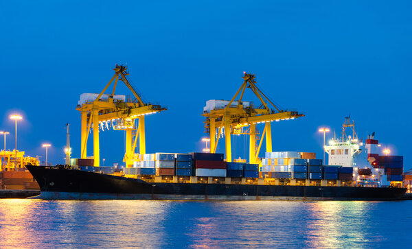 Грузовой контейнерный корабль с рабочим крановым мостом на судне
