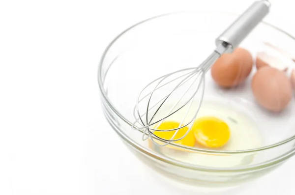 Проволочный венчик и коричневые яйца, изолированные на белом . — стоковое фото