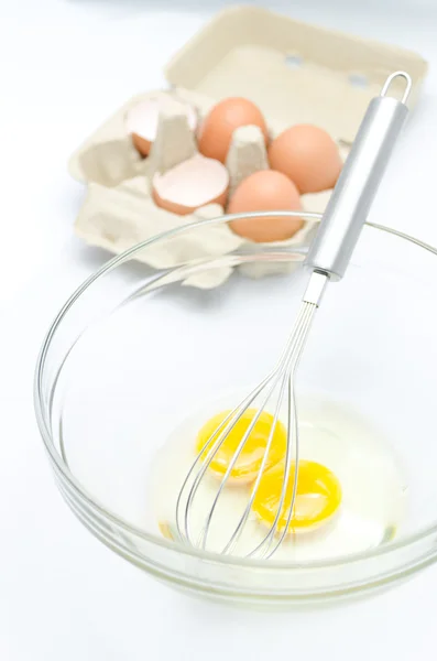 Проволочный венчик и коричневые яйца, изолированные на белом — стоковое фото