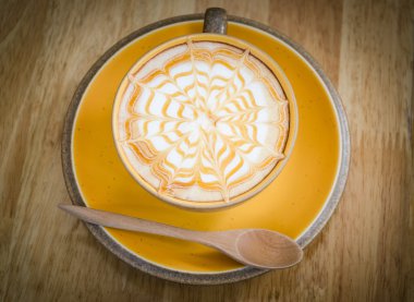 ahşap masa üzerinde bir latte kahve sanat.