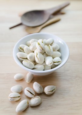 Antep fıstığı ahşap masa üzerinde bambu sepette beyaz izole