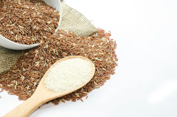 Arroz de jasmim e bagas de arroz em concha de madeira — Fotografia de Stock