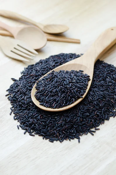 Bagas de arroz em uma concha de madeira, na mesa de madeira . — Fotografia de Stock