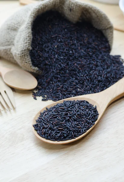 Rice berry in a wooden ladle, on wood table. — Stock Photo, Image