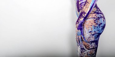 Sanatsal açıdan boyalı, mavi, mor, pembe, mor ve beyaz boyalı seksi bir kadının geniş kalça, el ve kol manzarası..