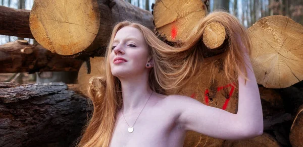 年轻而性感的红头发美女的性感迷人的画像在森林里的木堆前与美丽而华丽的红头发嬉笑 复制空间 — 图库照片
