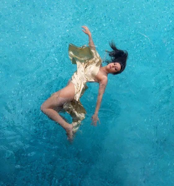 黄金の夜のドレスケープで美しい若いセクシーな人魚の女性のトップビュー 青で浮動無重力エレガントなスイミング ターコイズブルーのスパプールの水 コピースペース — ストック写真