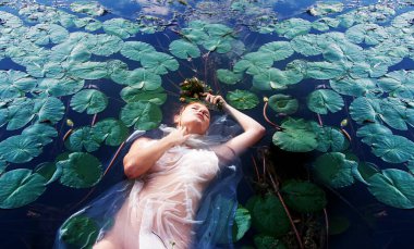 Genç, mutsuz, deli kadın Leydi Ophelia çürümüş çiçeklerle ölüyor. Gözleri beyaz elbiseler içinde su nilüferleri arasında, gölde, fotokopi odasında.