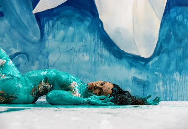 一个青绿色和白色的抽象画性感的裸体女人 躺在地板上的蓝色画室里 抽象画身体 复制空间 — 图库照片