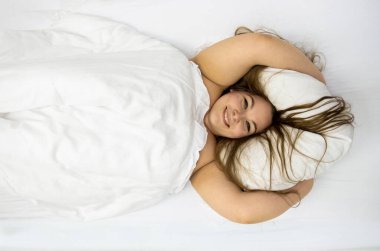 Mutlu, heyecanlı, kendinden emin, neşeli, tombul, uzun saçlı bir kadının portresi. Esmer, yakışıklı, kilolu bir kız. Güzel bir günün tadını çıkarıyor. Yatak odasında dinleniyor.