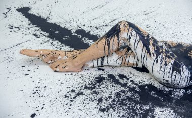 Siyah ve beyaz boyanmış bacaklar ve çıplak genç bir kadının ayakları, yaratıcı vücut resimleri, kopyalama alanı..