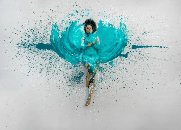 표현적 여성이 벌거벗은우아 자세로 바닥에 있습니다 파란색의 추상적 페인트칠을 물갈퀴가 — 스톡 사진