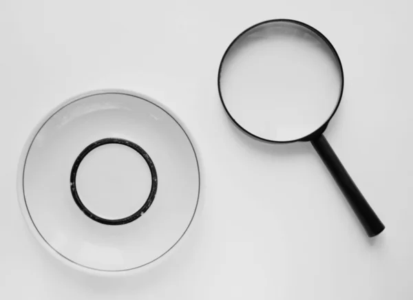 Saucer and loupe — Stock Photo, Image