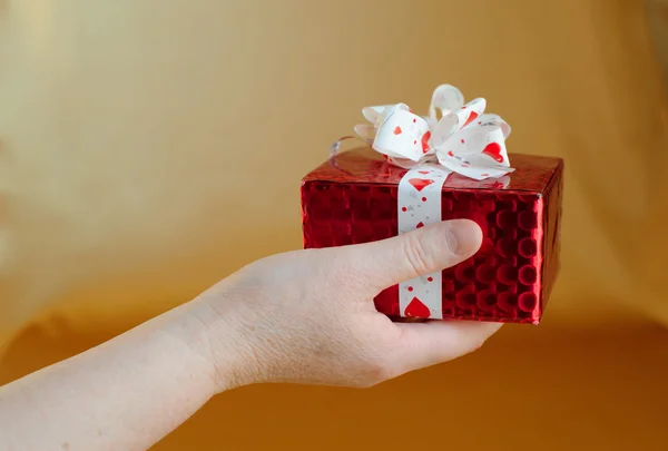Red gift box on hand — Stock Photo, Image