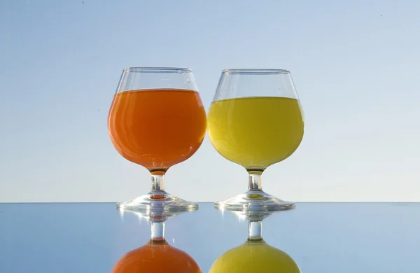 Glas met oranje en geel water — Stockfoto