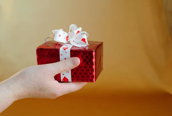 Red gift box on hand — Stock Photo, Image