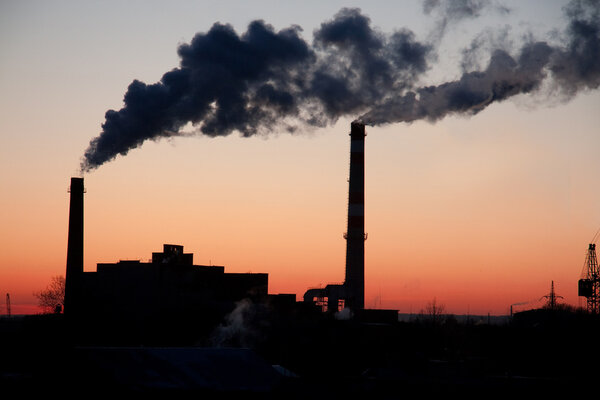 fuming industrial plant at sunset