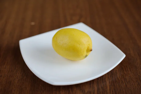 Fresh Lemon on a white plate — Stock Photo, Image