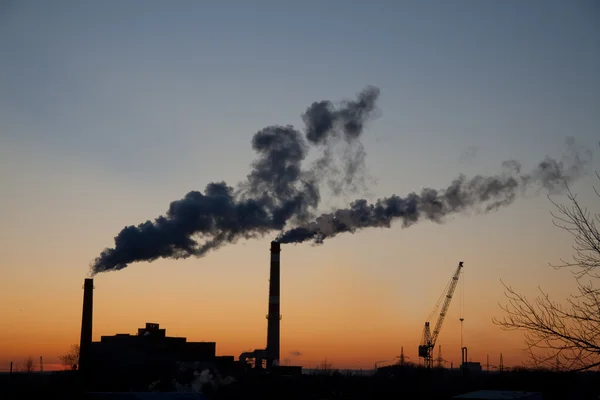 Rokend fabrieksinstallaties bij zonsondergang — Stockfoto